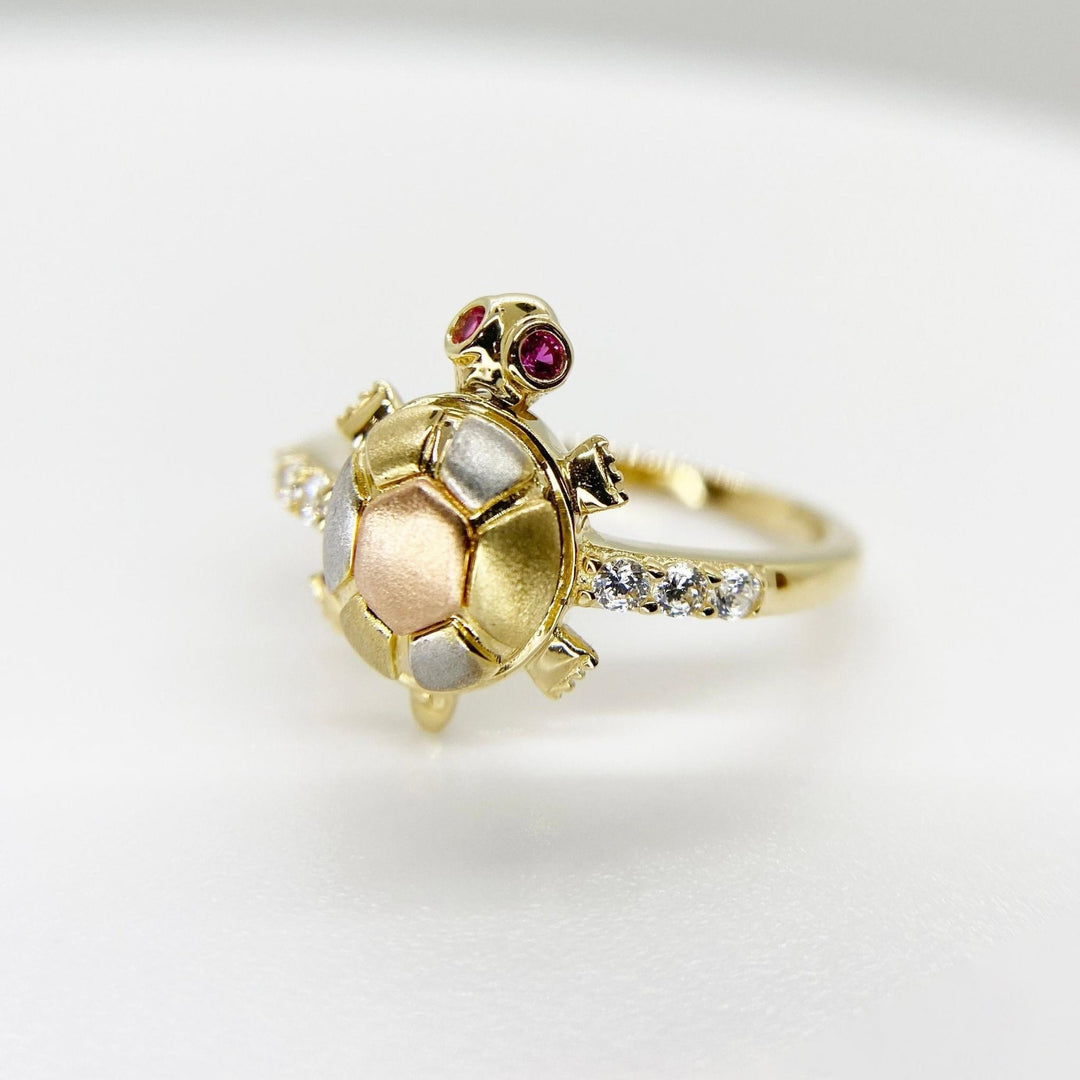 14k Gold turtle shaped ring with embedded Cubic Zirconia on a light gray background