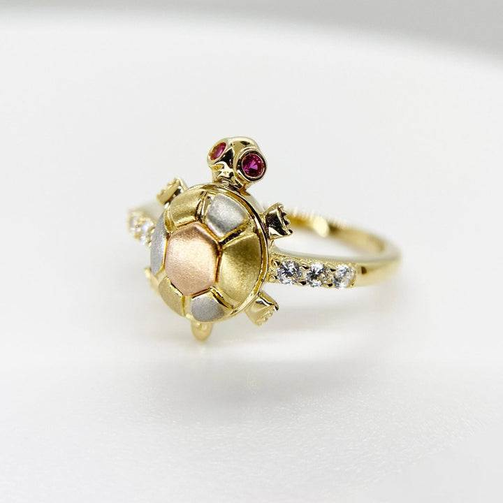 14k Gold turtle shaped ring with embedded Cubic Zirconia on a light gray background