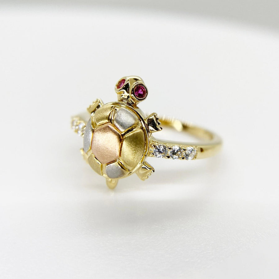14k Gold turtle shaped ring with embedded Cubic Zirconia on a light gray background