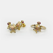 Front view of 14k gold tri-color turtle stud earrings displayed beside a matching ring.