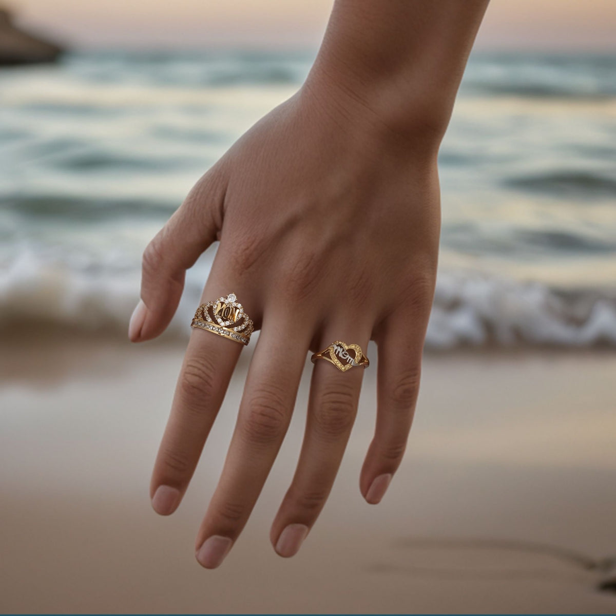Model wearing a gold queen crown ring and a nugget heart ring on her hand.