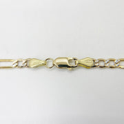 Detailed shot of a 14k gold pavé Figaro chain highlighting the lobster clasp closure.