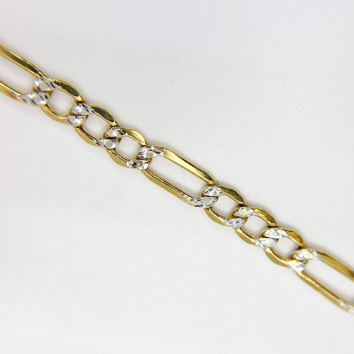Detailed shot highlighting alternating pavé and smooth links on 14k gold chain.