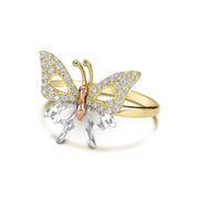 Side angle of a tricolor gold butterfly ring accented with cubic zirconia on white background.