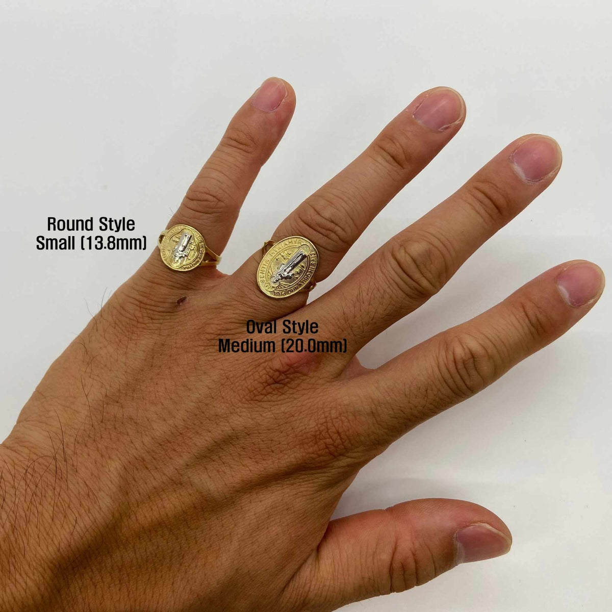 Hand wearing two 14k gold Saint Benedict rings with size labels on a white background