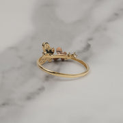 Back view of a 14k gold butterfly ring resting on gray marble.