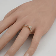 Dainty 14k gold butterfly ring worn on a finger against a plain background.