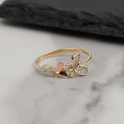Dainty two-tone 14k gold butterfly ring with cubic zirconia on white marble.