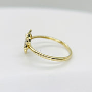 14k Gold ring with a cubic zirconia sideview on a light gray background