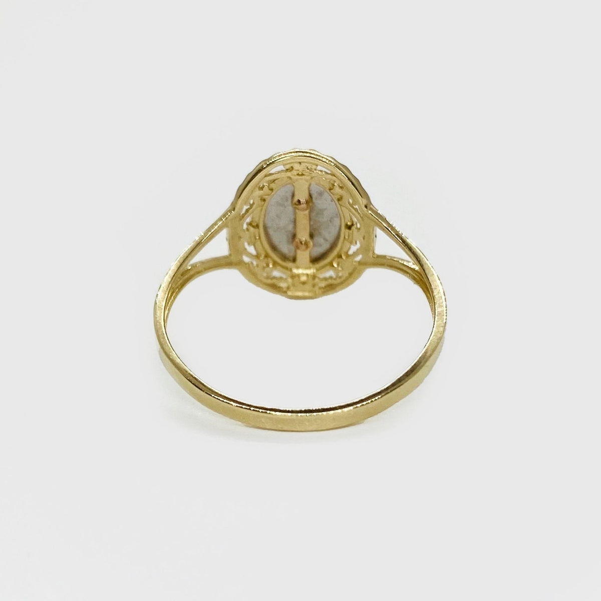 14k Gold ring with a oval shape design back view on a white background.