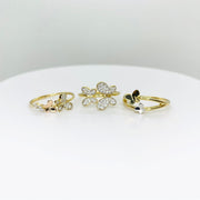 Three 14k gold rings with butterfly designs and three different style on a white surface