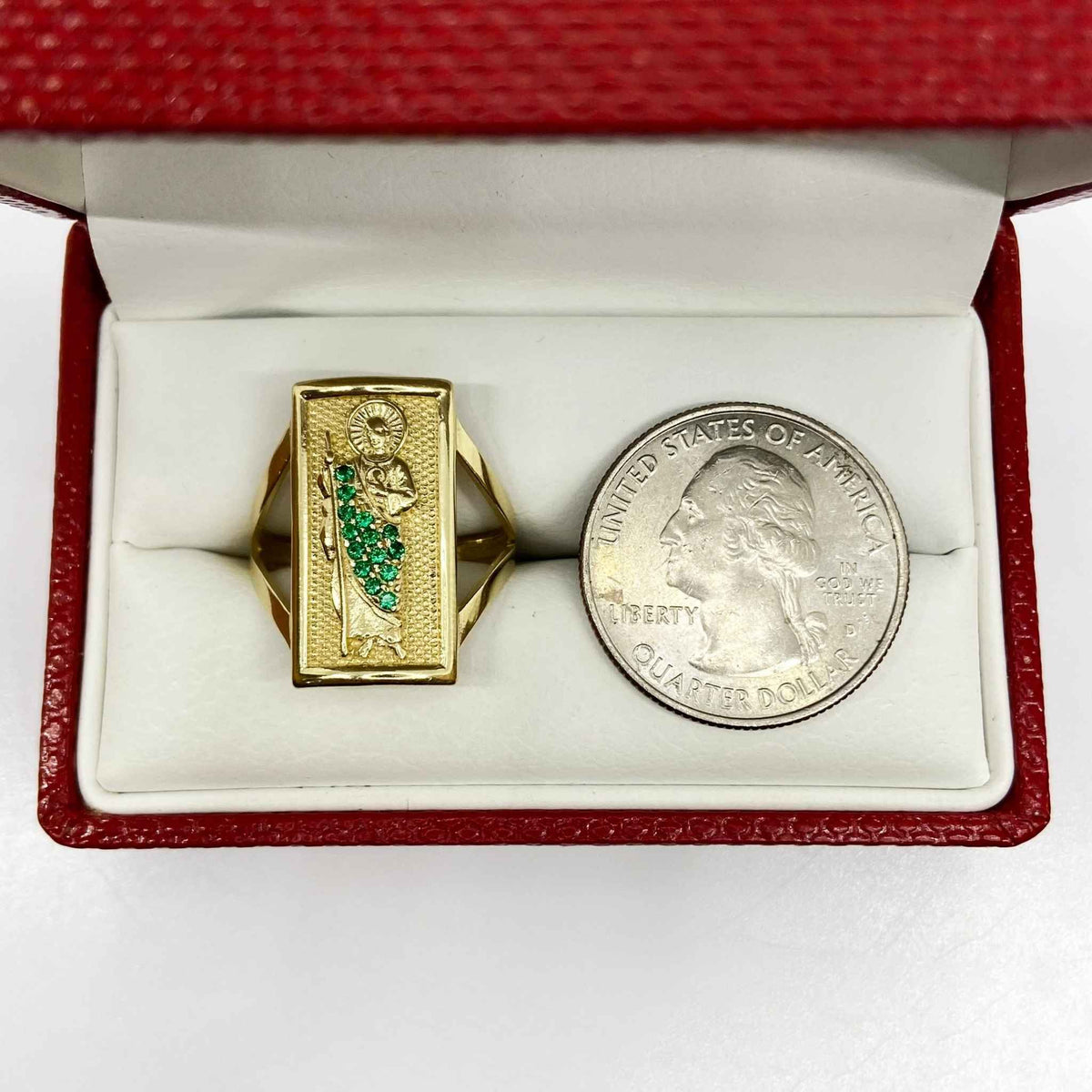 14k Gold ring with San Judas design next to a quarter in a red box.
