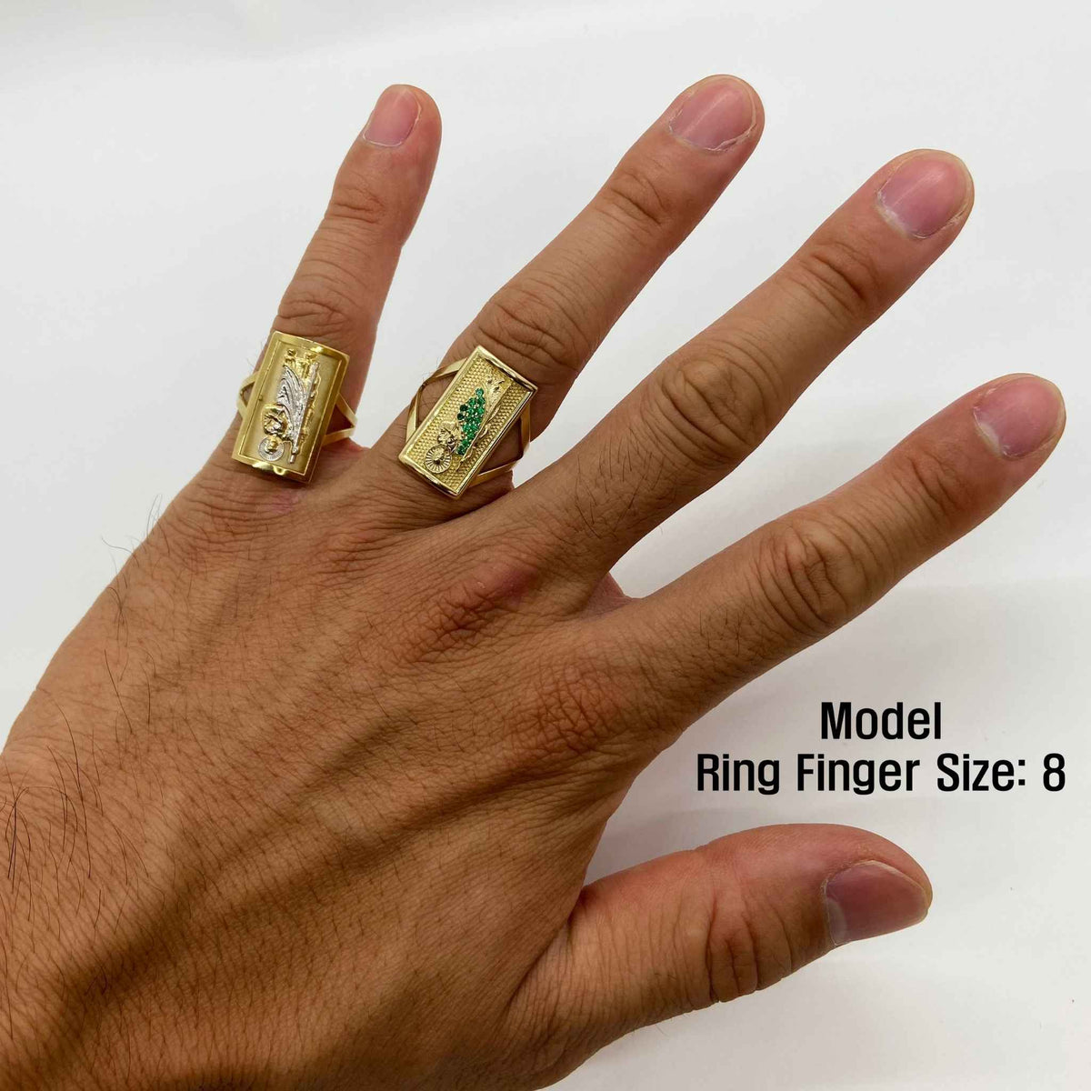 Hand wearing two 14k gold rings with  San Judas design white background.