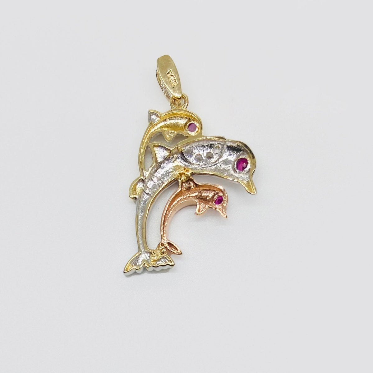 Back view of a 14k tri-color gold trio dolphin pendant displaying textured mesh structure.