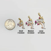 Three 14k tri-color gold trio dolphin CZ pendants shown next to a quarter for size scale.