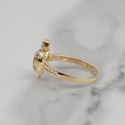 Side view of a gold turtle ring with CZ pavé band on marble.