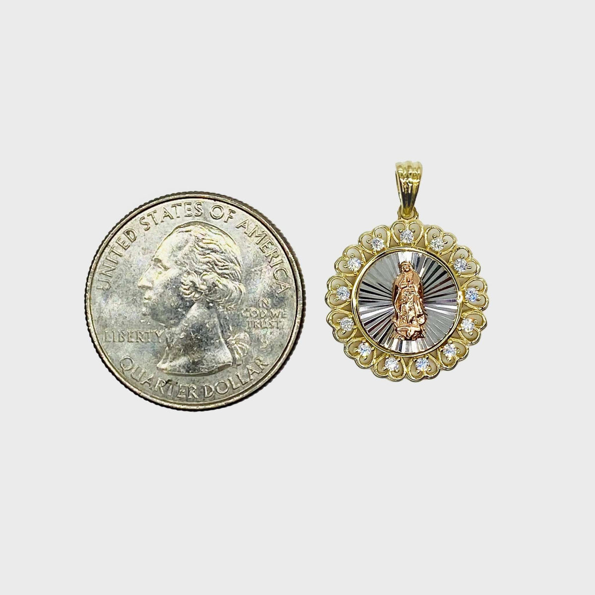 Size comparison of a 14k gold tri-color Virgin Mary round medallion pendant next to a US quarter.