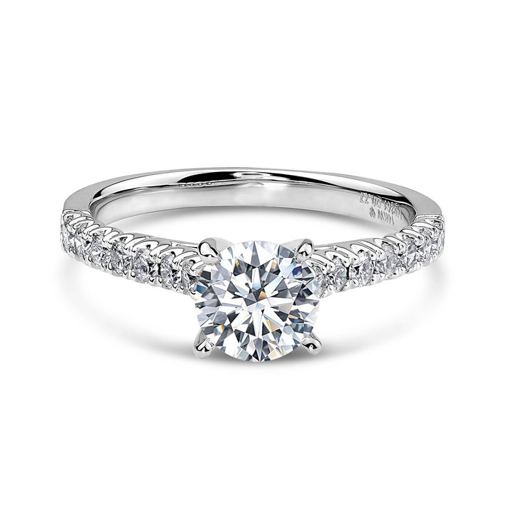 14k white gold engagement ring with a round diamond and a pavé band.