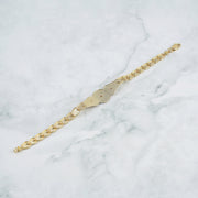 Flat lay shot of the multi-tone gold leaf link bracelet on a patterned background.