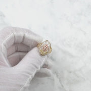 Gloved hand showcasing a rotating 10k and 14k gold Virgin Mary marquise ring.