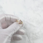 Gloved hand holding and rotating the 10k and 14k gold Alvia Virgin Mary ring.